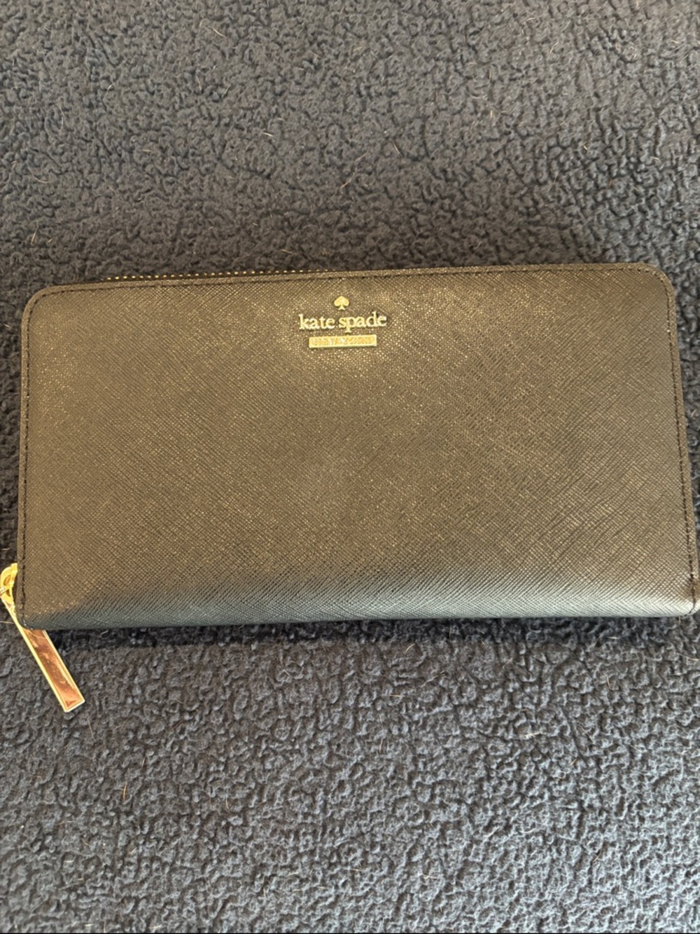 Kate Spade -  Black Saffiano Zip Around Wallet with gold logo.